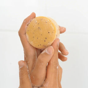 Seed & Sprout Citrus & Mint natural body wash bar held between hands creating a rich, and bubbly lather.