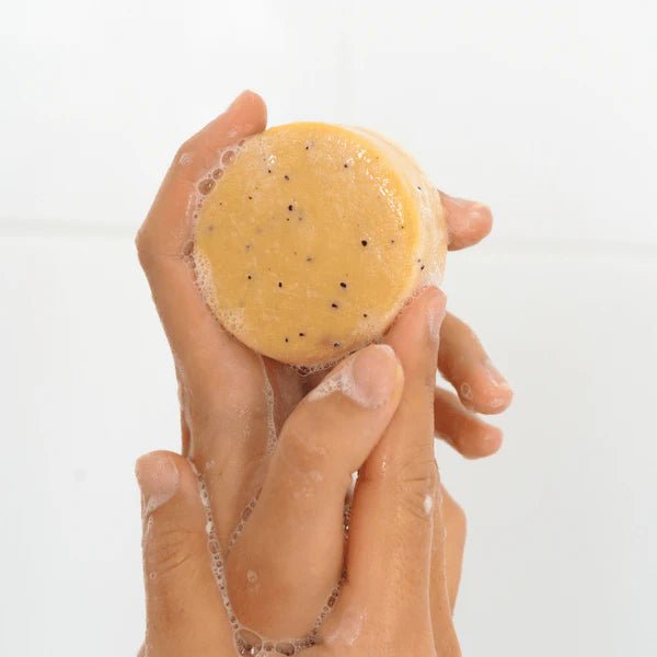 Seed & Sprout Citrus & Mint natural body wash bar held between hands creating a rich, and bubbly lather.
