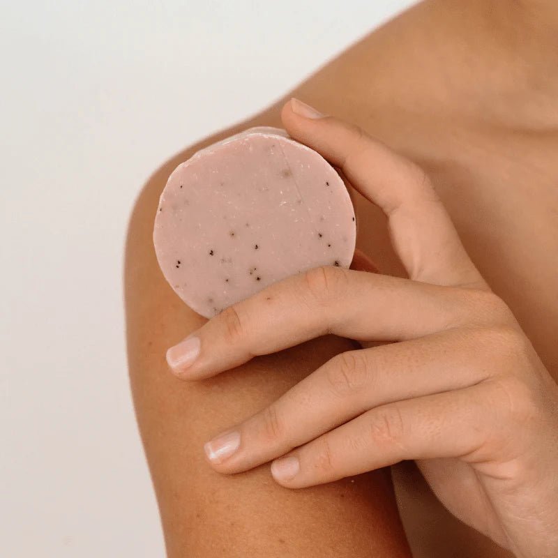 Seed & Sprout Rose Geranium natural body wash bar being held against the shoulder.