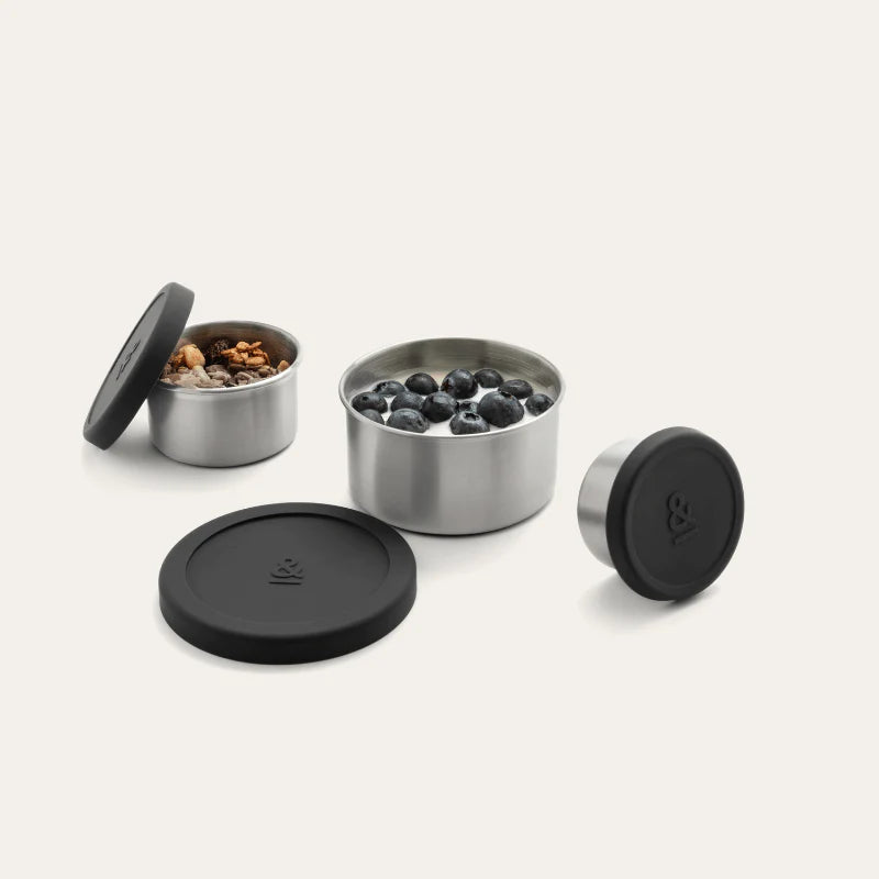 Seed & Sprout stainless steel nesting food containers with silicone lids, filled with yogurt, blueberries, and trail mix.
