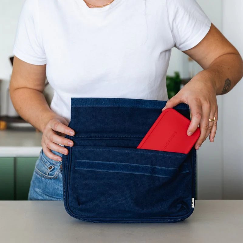 Seed & Sprout indigo organic cotton CrunchCase lunch bag with an open front pocket holding a bright red silicone ice pack.