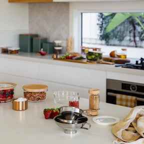 Seed & Sprout stainless steel funnel set displayed on a modern kitchen countertop alongside zero-waste food storage containers and fresh produce.