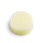 High-angle studio view of the Seed & Sprout Sweet Orange conditioner bar highlighting its smooth circular shape and creamy pale tone.
