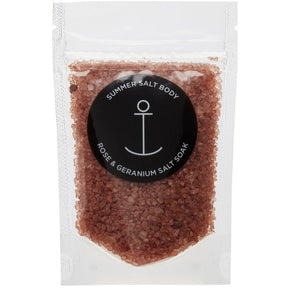 Summer Salt Body Rose and Geranium Salt Soak in clear resealable pouch with pink bath salts and black anchor logo